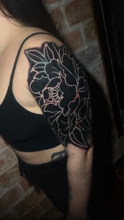 Composição floral preta no braço — trabalho de Thaís Muniz